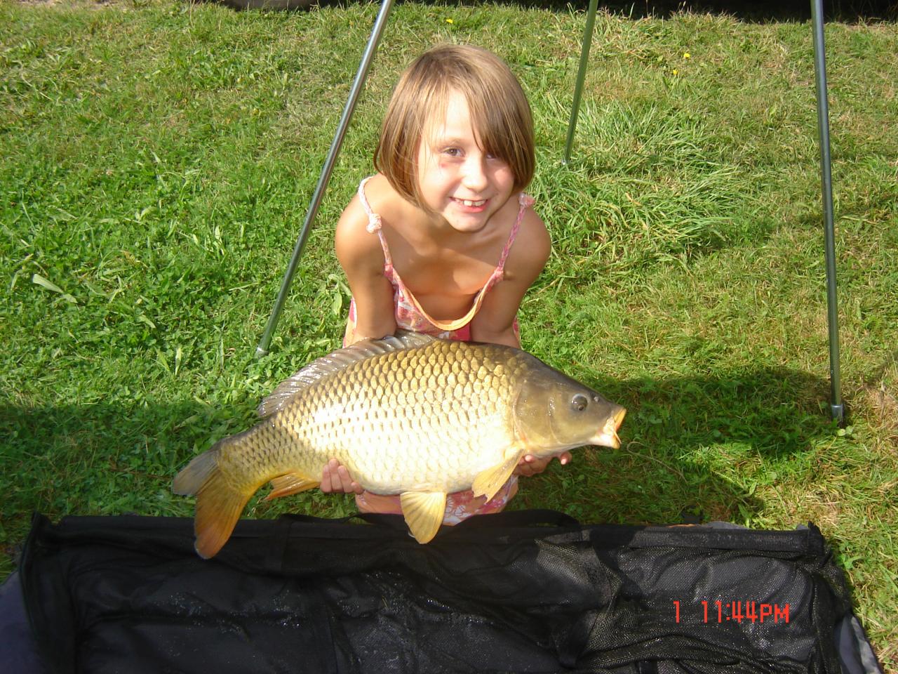 Un bebe, meme notre fille pose avec les carpes